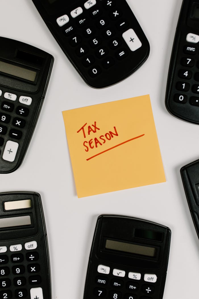 Top view of calculators surrounding a sticky note labeled 'Tax Season'.